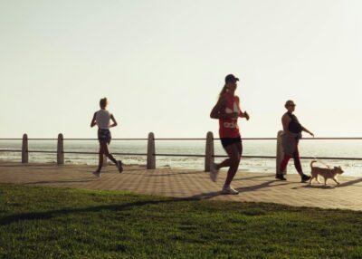 Active various women with dog on seafront.